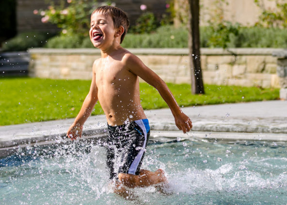 Ein Kind rennt in Badehose in einem leicht gesenktem Hubboden Pool.